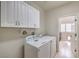 Functional laundry room with washer, dryer, and overhead cabinets, providing convenience and storage at 1104 Bower Basin St, Las Vegas, NV 89144