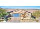 One-story house with blue garage door and desert landscaping at 1290 El Solindo Ln, Henderson, NV 89002