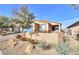 Tan house with blue garage door and drought-tolerant landscaping at 1290 El Solindo Ln, Henderson, NV 89002