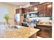 Kitchen with dark wood cabinets, granite countertops, and stainless steel appliances at 1290 El Solindo Ln, Henderson, NV 89002