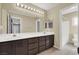 Double vanity bathroom with dark brown cabinets and a shower/tub combo at 1306 Big Tree Ave, North Las Vegas, NV 89031