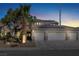 Two-story house with three-car garage, solar panels, and palm tree at dusk at 1306 Big Tree Ave, North Las Vegas, NV 89031