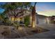 Two-story house with three-car garage, palm tree, and nighttime lighting at 1306 Big Tree Ave, North Las Vegas, NV 89031