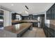 Spacious kitchen with dark cabinetry, large island, and stainless steel appliances at 1306 Big Tree Ave, North Las Vegas, NV 89031