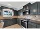 Modern kitchen with dark cabinets, granite countertops, and stainless steel appliances at 1306 Big Tree Ave, North Las Vegas, NV 89031