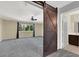 Spacious main bedroom with a barn door, ceiling fan and large window at 1306 Big Tree Ave, North Las Vegas, NV 89031