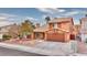 Two-story house with a brown garage door and desert landscaping at 1411 Bareback Ct, Henderson, NV 89014