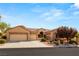 Single-story house with a three-car garage and beautifully landscaped front yard at 2563 Collinsville Dr, Henderson, NV 89052
