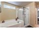 Relaxing bathroom with a soaking tub, walk-in shower, and window at 2671 Colina Bella Ct, Las Vegas, NV 89142