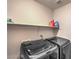 Convenient laundry room with washer, dryer, and overhead shelving at 2671 Colina Bella Ct, Las Vegas, NV 89142