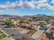 Expansive aerial view capturing homes with desert landscaping and mountain views set against a bright, cloud-strewn sky at 321 E Middleton Dr, Henderson, NV 89015