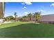 Large backyard with artificial turf, mature palm trees, and lounge seating at 321 E Middleton Dr, Henderson, NV 89015