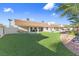 Spacious backyard features a well-kept lawn, tall palm trees, and a relaxing hammock, creating a serene outdoor space at 321 E Middleton Dr, Henderson, NV 89015