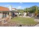 Lush backyard featuring a covered patio and desert landscaping, perfect for outdoor living and entertaining at 321 E Middleton Dr, Henderson, NV 89015