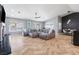 Open-concept living room with a large sectional sofa, herringbone flooring, and bright, natural light at 321 E Middleton Dr, Henderson, NV 89015