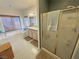 Clean bathroom featuring a tub, separate glass-enclosed shower, double vanity sink, and neutral tile at 3821 S Tumbleweed Ave, Pahrump, NV 89048