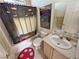 Bathroom with a shower and decorative shower curtain, toilet, sink and vanity with mirror at 3821 S Tumbleweed Ave, Pahrump, NV 89048