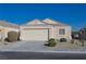 Tan colored house with a two-car garage and neatly landscaped yard at 5916 Naperville St, Las Vegas, NV 89130
