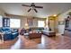 Spacious living room with L-shaped sofa, wood floors, and ceiling fan at 5916 Naperville St, Las Vegas, NV 89130