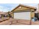 Home exterior featuring a white garage door and brick accents at 6442 Cedar Breaks Ave, Las Vegas, NV 89156