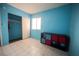 Bright bedroom with tile flooring, a window, and a storage unit; closet in view at 6443 Silverfield Dr, Las Vegas, NV 89103