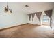 Open-concept living room with a light fixture, curtains, and carpeted flooring at 6443 Silverfield Dr, Las Vegas, NV 89103