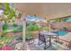 Outdoor patio area with table, chairs, lush landscaping, and refreshing pool at 725 Pacific Cascades Dr, Henderson, NV 89012