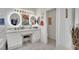 Bright bathroom featuring a double vanity with lighted mirrors, marble tile, a walk-in closet and a glass shower at 725 Pacific Cascades Dr, Henderson, NV 89012
