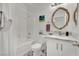 Bright bathroom featuring a shower-tub combo, elegant mirror, decorative tilework, and modern fixtures at 725 Pacific Cascades Dr, Henderson, NV 89012