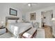 Bright bedroom featuring a king bed, plush carpet and seating with artwork, and entry to the bathroom at 725 Pacific Cascades Dr, Henderson, NV 89012