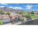 An exterior view with a well-manicured lawn and shrubbery, plus mountain views at 725 Pacific Cascades Dr, Henderson, NV 89012