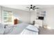 Cozy bedroom with a large window, ceiling fan, and beach art on the wall at 7733 Rosebark Cliffs St, North Las Vegas, NV 89084