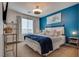 Bright bedroom showcasing a bold blue accent wall, comfortable bed, and natural lighting at 8736 Summoners Ct, Las Vegas, NV 89139
