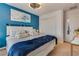 Bright bedroom showcasing a bold blue accent wall, comfortable bed, and contemporary decor at 8736 Summoners Ct, Las Vegas, NV 89139