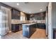 Stylish kitchen featuring dark cabinets, stainless steel appliances, island, and wood floors at 8736 Summoners Ct, Las Vegas, NV 89139