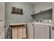 Well-organized laundry room with washer, dryer, and storage shelf at 8736 Summoners Ct, Las Vegas, NV 89139