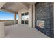 An outside balcony with a stone fireplace and sliding glass doors at 10000 Cresent Mesa Ln, Las Vegas, NV 89145