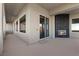 A covered balcony with a stone fireplace and sliding glass doors at 10000 Cresent Mesa Ln, Las Vegas, NV 89145