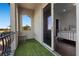 Balcony with synthetic grass overlooks the street, seamlessly connecting to the bedroom at 10000 Cresent Mesa Ln, Las Vegas, NV 89145