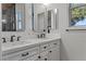 Bright bathroom with a double vanity, white countertop, decorative mirrors, and natural light at 10000 Cresent Mesa Ln, Las Vegas, NV 89145