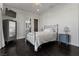 A stylish bedroom with dark hardwood floors, a ceiling fan, and light gray walls at 10000 Cresent Mesa Ln, Las Vegas, NV 89145