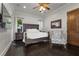 A bedroom with hardwood floors, a ceiling fan, and a patterned arm chair at 10000 Cresent Mesa Ln, Las Vegas, NV 89145
