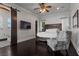 A bedroom with a dark hardwood floor, ceiling fan, and sliding barn door to the bathroom at 10000 Cresent Mesa Ln, Las Vegas, NV 89145