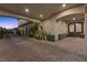 Covered driveway featuring detailed brickwork, lush greenery, and convenient access to the home's entrance at 10000 Cresent Mesa Ln, Las Vegas, NV 89145