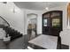 Elegant foyer with staircase and dark wood floors that leads to an adjacent living area with fireplace at 10000 Cresent Mesa Ln, Las Vegas, NV 89145