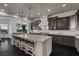 Bright kitchen with island seating, custom range hood, and a view to the backyard at 10000 Cresent Mesa Ln, Las Vegas, NV 89145