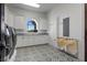 Bright laundry room with stylish patterned floors, white cabinetry, and stainless steel washer and dryer at 10000 Cresent Mesa Ln, Las Vegas, NV 89145