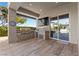 Covered outdoor kitchen features stainless steel appliances, a stone backsplash, and a view of the pool at 10000 Cresent Mesa Ln, Las Vegas, NV 89145