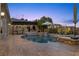 A luxurious pool and spa combination surrounded by beautiful wood decking and lush landscaping at 10000 Cresent Mesa Ln, Las Vegas, NV 89145