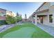 A backyard featuring a custom putting green, covered patio, and tiered landscaping creates a perfect outdoor retreat at 10116 Rebel Coast St, Las Vegas, NV 89141